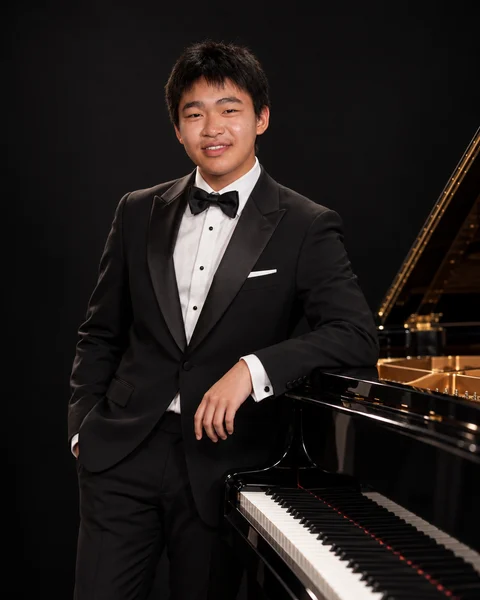 Cameron Lu beside a grand piano